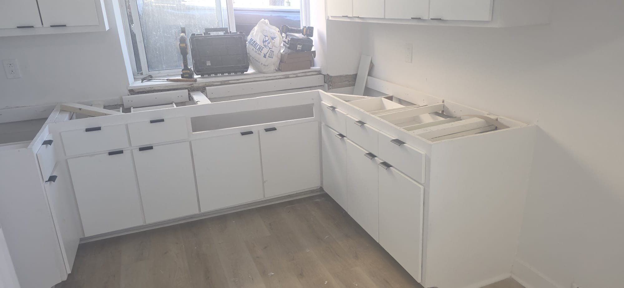 White base cabinets installed along a kitchen wall and corner.