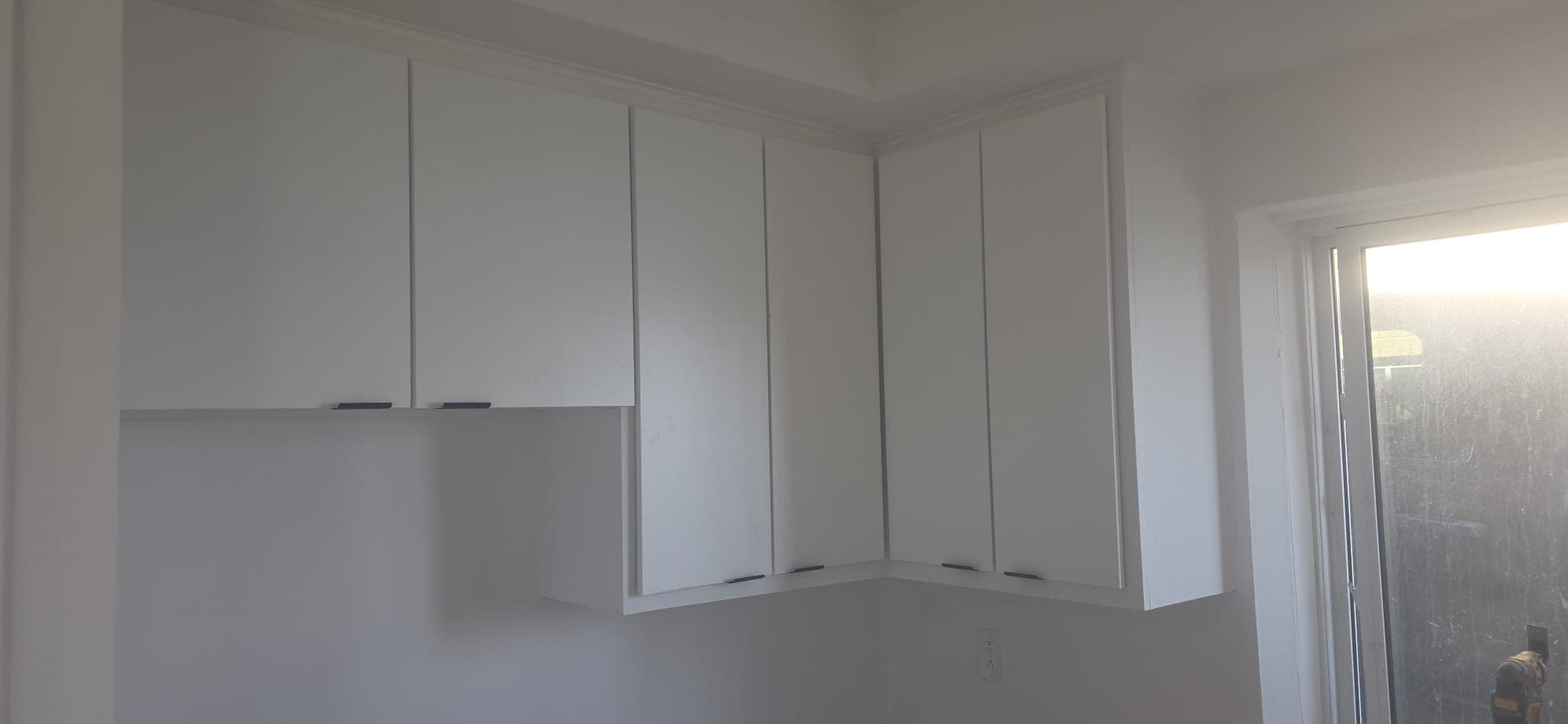 Upper-cabinet corner finished with crown moulding along the ceiling.